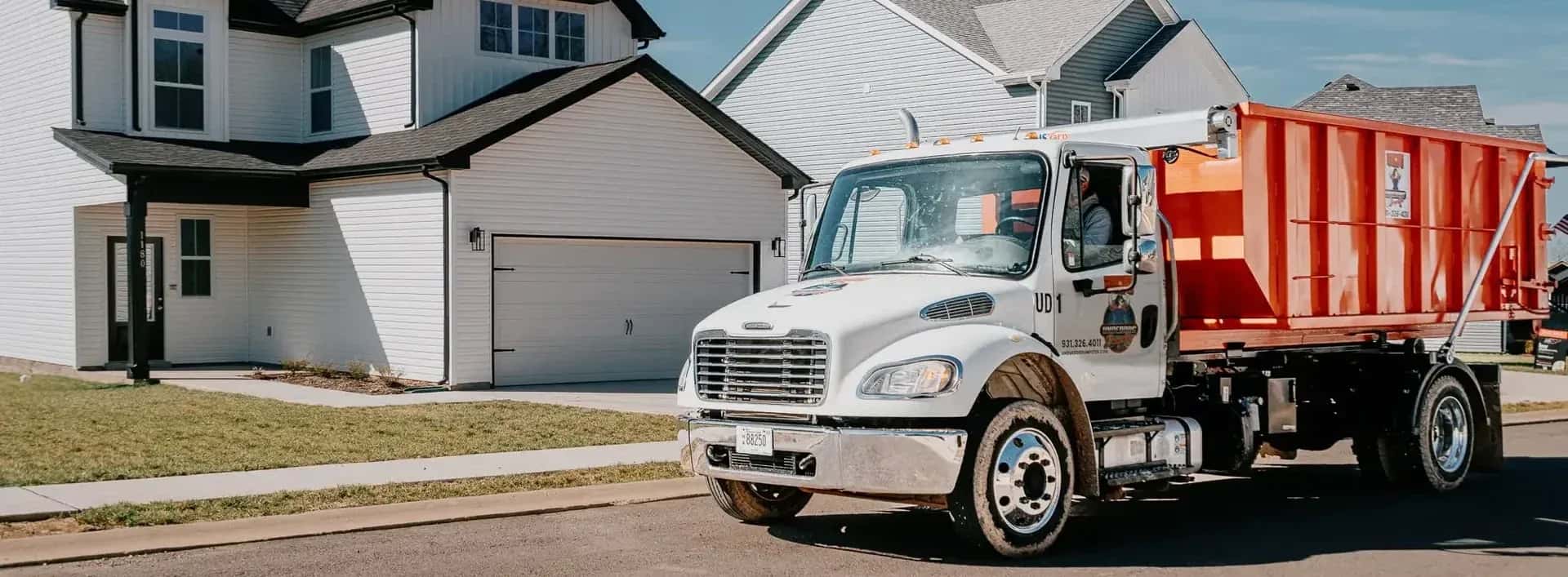 Underdog Dumpster roll-off truck delivering a dumpster to a Clarksville driveway